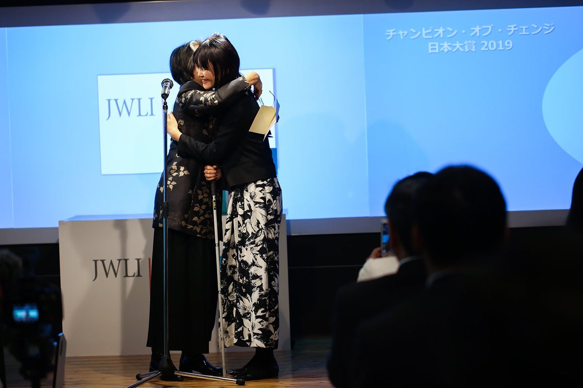 two people hugging on stage